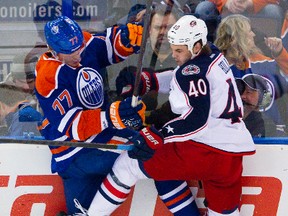 Oilers defenceman Anton Belov battles Blue Jackets Jared Boll against the boards during first-period action Tuesday at Rexall Place. (Amber Bracken, Edmonton Sun)