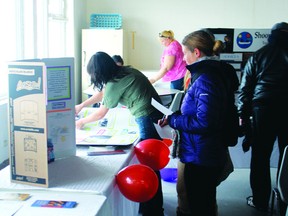 People look at the dispays at the Fellowship Centre’s open house on Tuesday, Nov. 19, which aimed to educate the community on all the work the shelter does.