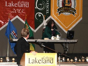 Cathy Wolters, Lakeland College Historical Acknowledgement co-chair opens the time capsule created in 1988 on the college’s 75th Anniversary, as co-chairperson and MC for the evening, Peter Walsh looks on.
