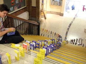 A Grade 10/11 gym class from Sarnia Collegiate spent Thursday morning setting up almost 1,000 boxes of macaroni and cheese. Colton Osborne helped make sure the dominoes were set in the proper place before knocked down. Afterwards they were donated to local food banks. (MELANIE ANDERSON, The Observer)