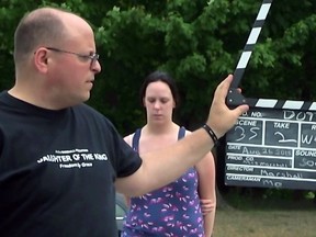 Filmmaker Matt Marshall holds the slate for a shot with actress Debra van Gaalen, featured in his eighth indie production, Daughter of the King.