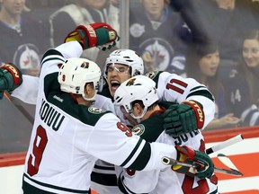 Nov 23, 2013; Winnipeg, Manitoba, CAN; Minnesota Wild forward Zach Parise (11) celebrates his goal with teammates during the third period against the Winnipeg Jets at MTS Centre. Wild win 3-2. Mandatory Credit: Bruce Fedyck-USA TODAY Sports