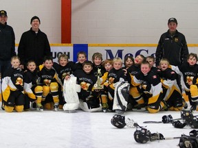 Members of the Mitchell Atom AE's celebrate their overtime victory Sunday to win the Elma Logan atom division championship.