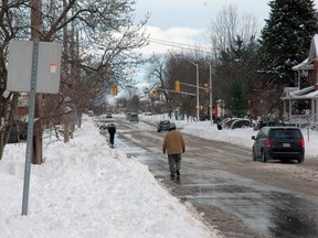 Pedestrians take to the streets Monday as most city sidewalks remain buried under as much as 70 cm of snow dumped on St. Thomas over the weekend. According to a snow removal update from the city, it could take up to two weeks to clear all sidewalks.
