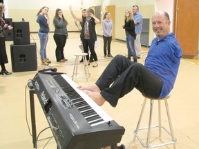 Guest Speaker Alvin Law demonstrates his skills with his feet while playing the piano, with some student volunteers in the background. Law discussed his 'Five Steps for Overcoming Anything' with students at Wingham's F.E. Madill Secondary School on Nov. 18, 2013.