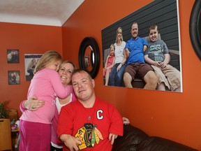 Nancy and Matthew Landry, and their daughter, Reegan, 4, pose next to a family picture that includes their son, Jordan, who passed away in September.  JOHN LAPPA/THE SUDBURY STAR