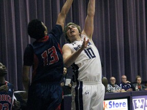 Western Mustang Peter Scholtes tries to get a left-handed shot over Brock defender Dani Elgadi during OUA action at Alumni Hall on Nov. 27. Scholtes – a London native – had 17 points in a 88-78 loss.
JACOB ROBINSON/LONDONER/QMI AGENCY