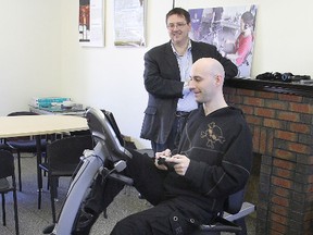 Dr. Nick Graham looks on as PhD student Chad Richards tries out the video game/exercise system Queen's researchers are using in an upcoming study to improve children's fitness levels.
Michael Lea The Whig-Standard