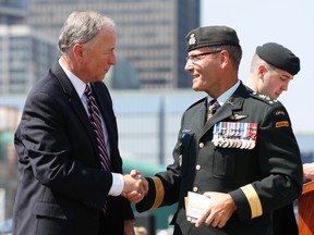 Canada's Defence Minister Rob Nicholson (L) shakes hands with Lieutenant-General Marquis Hainse, the new commander of the Canadian Army, during a change of command ceremony on Parliament Hill in Ottawa July 18, 2013. (REUTERS/Chris Wattie)