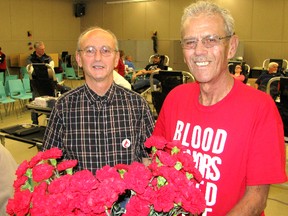 Don Wadsworth (left) gave his 50th unit of blood Thursday at a blood donor clinic at Wallaceburg, and was promptly thanked by 65-year-old Bob Arthur, a leukemia patient who receives a weekly blood transfusion of two units. Arthur attended Thursday’s clinic to express his personal appreciation to Wadsworth and other donors, while giving them each a red carnation.