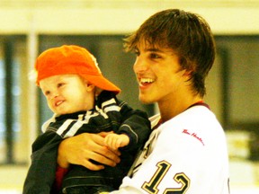 The Saints Dylan Hollman, shown here with a young fan during one of the Skate With The Saints days at Grant Fuhr Arena, was named the AJHL’s CanAlta Hotels Player of the Week, partly for his five goal, six point night in a 10-2 win over the Olds Grizzlys on Nov. 23. - Gord Montgomery, Reporter/Examiner