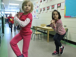 Stony Plain Central School’s Grade 1 students Taylor Suchoplas (left) and Addison Litvinchuk take part in the school’s 15-minute, daily physical activity that happens each morning. Here the students follow along practising yoga on Nov. 25. - Karen Haynes, Reporter/Examiner