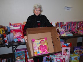 Christmas Care coordinator Andreana Collins stands with some of the items collected  for the program, which provides toys and food to people in and around St. Thomas at Christmastime. (Times-Journal file photo)