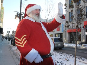Randy Young, playing Sergeant Santa, waves to passing motorists on Princess Street Friday morning as he stops in the city on his cross-province toy drive for the children of military personnel.
Michael Lea The Whig-Standard