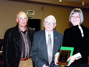 Flanked by son Dave, left, the Hon. Ralph Ferguson is presented with a plaque from Lambton County Agricultural Hall of Fame (LCAHF) chairperson Joanne Sanderson in commemoration of Mr. Ferguson’s induction into the LCAHF.