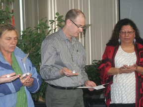 Rev. Mark Perry of St. Andrew's United Church reads a prayer during a candlelit vigil held at the office of AIDS Support Chatham-Kent on Dec. 3. The event was held in conjunction with World AIDS Day and Aboriginal AIDS Awareness Week.