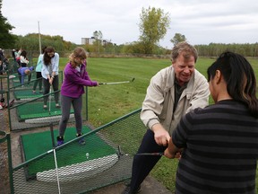 Golf pro John Colwell instructs Loyalist Collegiate student Leah Luckwaldt Ross, 16, at a clinic at Belle Park Fairways on Oct. 4. Belle Park will remain open in 2014. (Elliot Ferguson/The Whig-Standard)