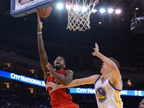 Toronto Raptors power forward Amir Johnson (15) shoots the basketball against Golden State Warriors power forward David Lee (10) during the second quarter at Oracle Arena. (Kyle Terada-USA TODAY Sports)