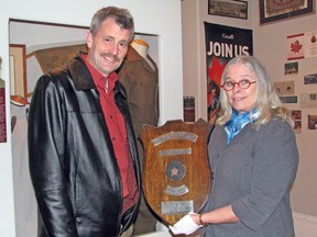 The Stratford Perth Museum welcomes visitors to their upcoming exhibit, 'The Good Old Hockey Game', opening mid-December. Micaela Fitzsimmons (right), manager of collections and exhibits at the museum, holds a local championship plaque won by former Toronto St. Pats’ forward and World War II veteran Reg Reid and his teammates in 1940. She is joined by Mitchell resident Stephen Benedict, Reid’ grandson. KRISTINE JEAN/MITCHELL ADVOCATE