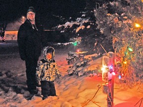 Two-year old Hunter Koene and his uncle Jamie Koene admire the lights in Centennial Park after the tree lighting ceremony in downtown Mitchell last Friday, Nov. 29.  KRISTINE JEAN/MITCHELL ADVOCATE