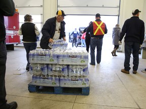Loyalist firefighters hand out cases of bottled water to residents after a drinking water advisory was put in place for most of the township. The advisory is expected to remain in place until near the end of the week.
Elliot Ferguson The Whig-Standard