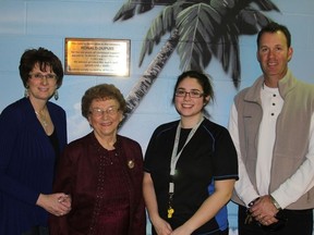 Roberta Dupuis, Ron's daughter, Denise Vandal, Ron's eldest sister, Kayla Tousignant, THEC lifeguard and Terry Vachon, Director of Community Services, stand below the plaque that now hangs beside the THEC pool in honour of Ron Dupuis.