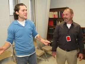 Daren Dougall, right, executive director of the Youth Diversion program, listens as Collins Bay institution inmate Jarrod Shook explains how the inmates raised $500 for the program through two charity runs.
Michael Lea The Whig-Standard