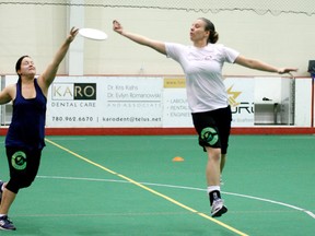 Dani Dugan (left) and another ultimate player reach for a throw during a demonstration of the sport at the TLC. - Gord Montgomery, Reporter/Examiner