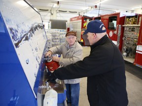 Loyalist fire captain Carl Jalabert helps Jack Mol fill water jugs from a CIty of Kingston water trailer at the Amherstview fire station Friday morning.
Elliot Ferguson The Whig-Standard