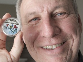 Odessa-area artist Richard De Wolfe holds the $20 silver commemorative coin produced by the Canadian Mint that has one of his paintings on it.
Michael Lea The Whig-Standard