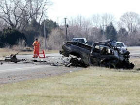 Members of the Chatham-Kent police traffic unit survey the scene of a fatal crash on Queen's Line just west of Chatham Saturday. The collision between a grain hauler and pickup truck just before 10 a.m. killed the driver of the pickup and sent the other driver to hospital with unknown injuries. Diana Martin/Chatham Daily News/QMI Agency