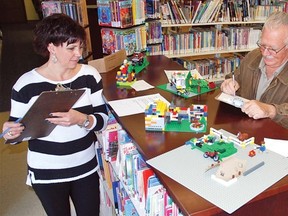 Vulcan library board members Paul Taylor, right, and Harvey Bergen, as well as librarian Cheryl Cochlan, judged Nov. 29 submissions to the Vulcan Municipal Library’s inaugural Lego building contest.