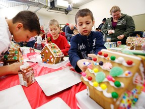 Belleville brothers Dominick, left, and Tyrel Cottrell, right, build up their holiday spirit while supporting Habitat for Humanity Prince Edward Hastings by building gingerbread houses with Nathan Lavigueur, centre, at the organization's ReStore on Bell Boulevard in Belleville, Ont. Saturday, Dec. 7, 2013. Bob Clute chaired the event, while Wayne Dewe and Dewe's Your Independent Grocer provided dozens of gingerbread houses for the free family, holiday initiative. — JEROME LESSARD/The Intelligencer