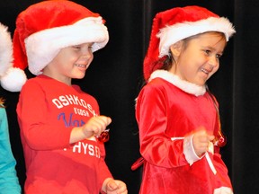 Smiling Ayden Wood (left) and Selena Lee jingle their bells, two of approximately 140 students from the seven kindergarten classes at Upper Thames Elementary School (UTES) to perform their Christmas concert last Wednesday, Dec. 4 at the jam-packed UTES gymnasium. ANDY BADER/MITCHELL ADVOCATE