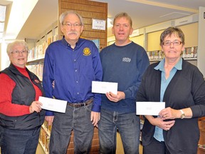 The Mitchell Lions Club and the IPM 2013 Lifestyle Committee teamed up together during the IPM last September to help raise funds for various community groups and projects. Several thousand dollars was raised from a quilt raffle draw held, and was donated back to the community. From left are: June Demerling, IPM lifestyle committee member; Allen Muegge, Mitchell Lions Club; Rick Vivian, facilities manager with the Municipality of West Perth; and Caroline Shewburg, head librarian at West Perth Library.  KRISTINE JEAN/MITCHELL ADVOCATE