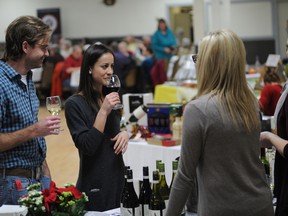 Patrons enjoy a glass of wine while sampling locally made cheese.