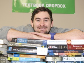 Chris Janssen amid a pile of textbooks that that he donates to schools in Africa.