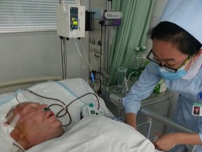 Michael Jutras, 55, originally from Sarnia is pictured in hospital in Nanjing, China, where he recently underwent brain surgery after a sudden hemorrhage. His family is crowdsourcing to help cover the $30,000 Jutras' health insurance didn't cover for the procedure. (Submitted photo)