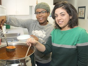Queen's students Priscila Mbanianga, left, and Nilita Sood work in the kitchen at the Ban Righ Centre. (Michael Lea The Whig-Standard)