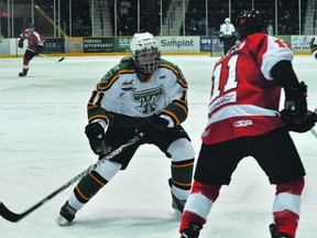 Portage Terriers forward Devin Muir goes to check Winkler's Regan Stire during the Dec. 12 Portage Terriers vs. Winkler Flyers game. (Kevin Hirschfield/THE GRAPHIC/QMI AGENCY)