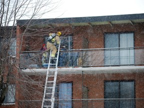 A St. Thomas firefighter rescues a man, a woman and their young grandchild by ladder from the third-floor balcony of their Parkside Dr. apartment after a fire broke out over the noon hour Friday. Dozens of residents were forced out of their homes overnight. (BEN FORREST, Times-Journal)