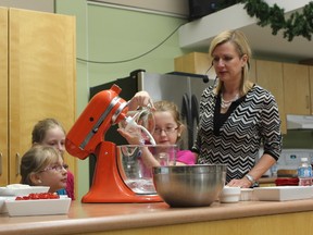 Natalie, 10, pours water into a mixing bowl as she helps celebrity chef Anna Olson whip up a batch of her Grandma Julia?s Potato Cheddar Pierogy Bread