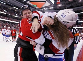 Ottawa Senators' Chris Neil, right, fights for control of the puck