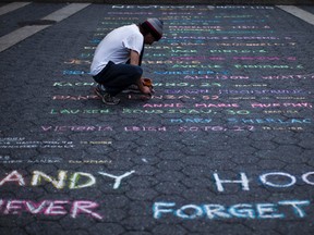 Street artist Mark Panzarino prepares a memorial as he writes the names of the Sandy Hook Elementary School victims during the six-month anniversary of the massacre, at Union Square in New York, June 14, 2013. 
REUTERS/Eduardo Munoz/QMI AGENCY