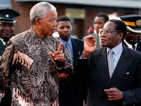 South Africa's President Nelson Mandela (L) and his counterpart Robert Mugabe of Zimbabwe talk in Zimbabwe in this May 21, 1997 file photo.   REUTERS/Howard Burditt/Files