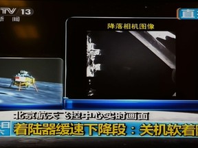 This screen grab taken from CCTV live broadcasting footage shows an image (R) of China's first lunar rover transmitted back to the control centre in Beijing after it landed on the moon on December 14, 2013.  AFP PHOTO / CCTV