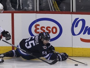 Winnipeg Jets centre Mark Scheifele loses his balance under pressure from Dallas Stars defenceman Kevin Connauton during first-period NHL action at MTS Centre in Winnipeg, Man. on Sat., Dec. 14, 2013. Kevin King/Winnipeg Sun/QMI Agency