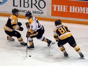 Sarnia Sting forward Nikolay Goldobin tries to cut between Kingston Frontenacs defenceman Mike Moffat (number 4) and forward Connor McGlynn (number 81) in the first period of their game in Sarnia on Saturday night. The Fronts beat Sarnia 9-1. SHAUN BISSON/THE OBSERVER/QMI AGENCY