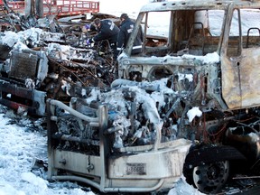 Fire investigators continue to work at the scene of an early morning fire that destroyed several tractor trailer units at Hi-Way 9 Express Ltd., 6031 - 66A Ave., in Edmonton, Alta., on Sunday Dec. 15, 2013. David Bloom/Edmonton Sun/QMI Agency