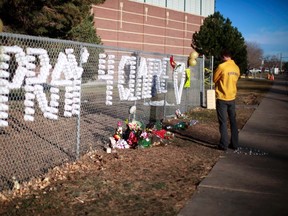 An Arapahoe high school student prays at the school in Centennial, Colorado December 15, 2013. Claire Davis, a 17-year-old Colorado high school senior shot in the head December 13 by a heavily-armed classmate who stormed the school remained in critical condition, the county sheriff said. (REUTERS/Rick Wilking)